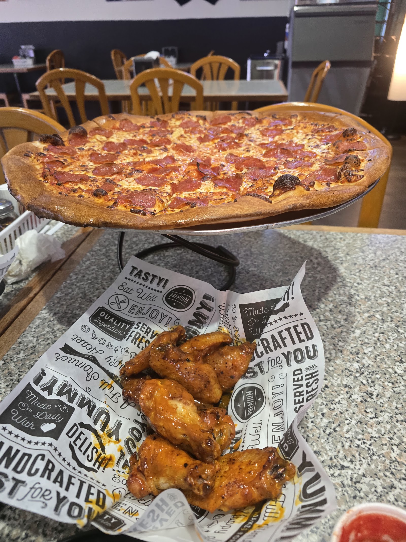 Signature pizza and a tray of wings served at Big Papa's Pizza & Sports